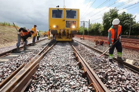 L'engin de la société Meccoli est chargé de soulever le rail pour bourrer les 25 centimètres de ballast. Photo : P. Messelet